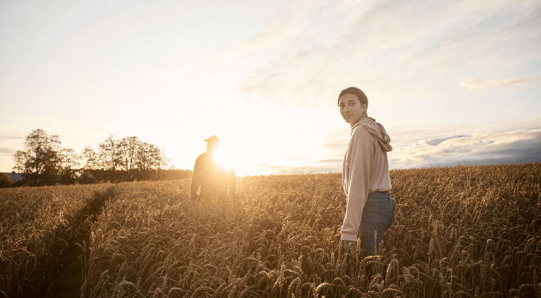 Un agriculteur et sa fille dans un champ de blé
